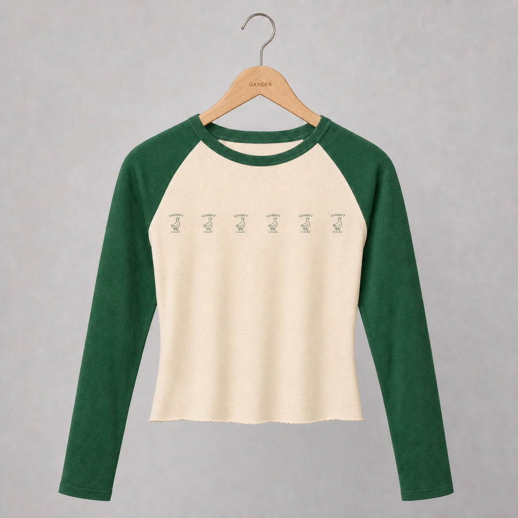 Women’s fitted hand-cropped cream and green Goosey baseball tee on a Gander wooden hanger